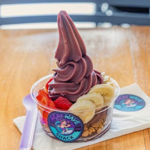 Acai bowl with a tall swirl of soft-serve acai, strawberries and banana